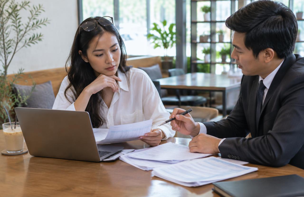 Thai remote worker reviewing financial evidence with a lawyer