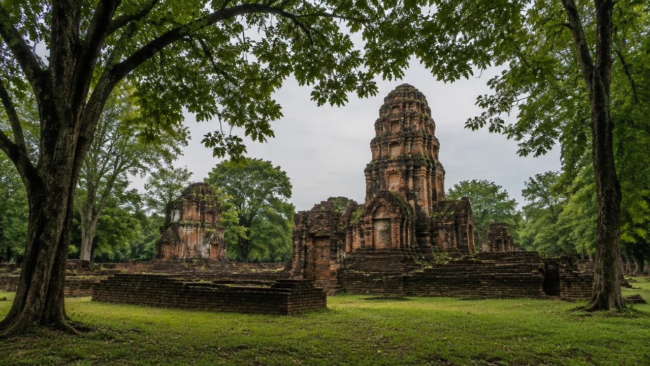 โบราณสถานศิลาแลงและอิฐในอุทยานประวัติศาสตร์กำแพงเพชร ท่ามกลางต้นไม้ใหญ่และสนามหญ้าเขียว
