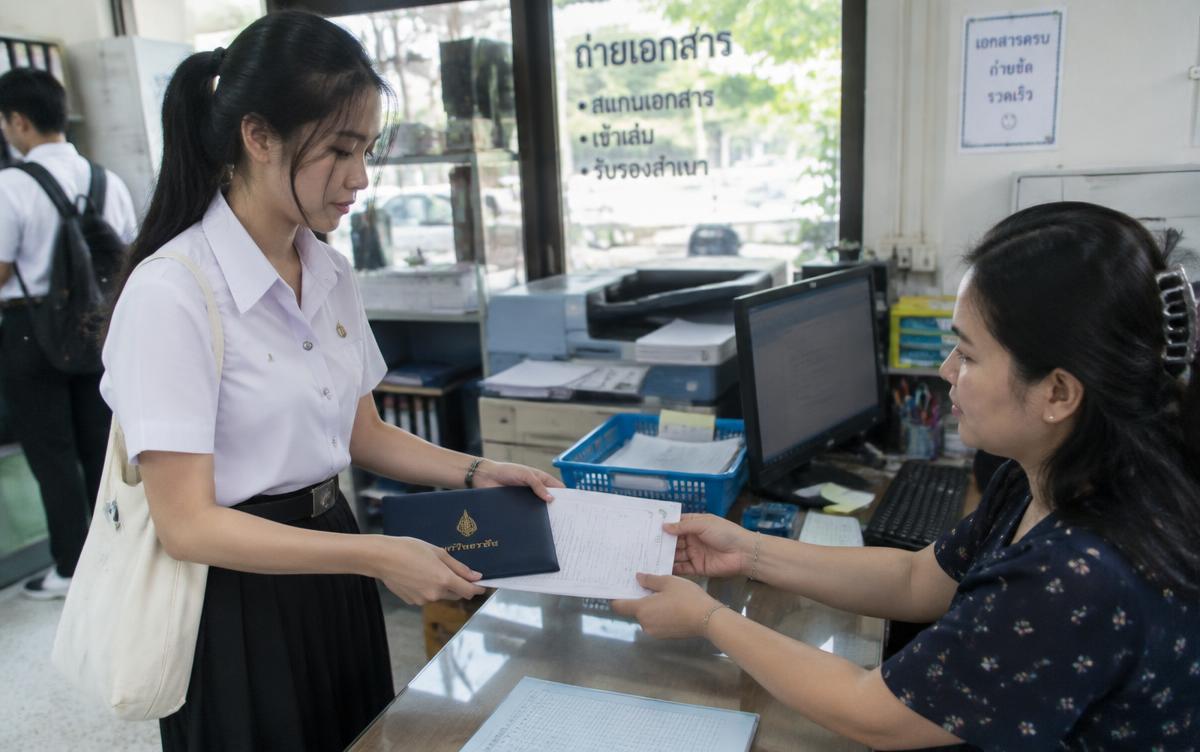 Thai student handing in a diploma and transcript for copying