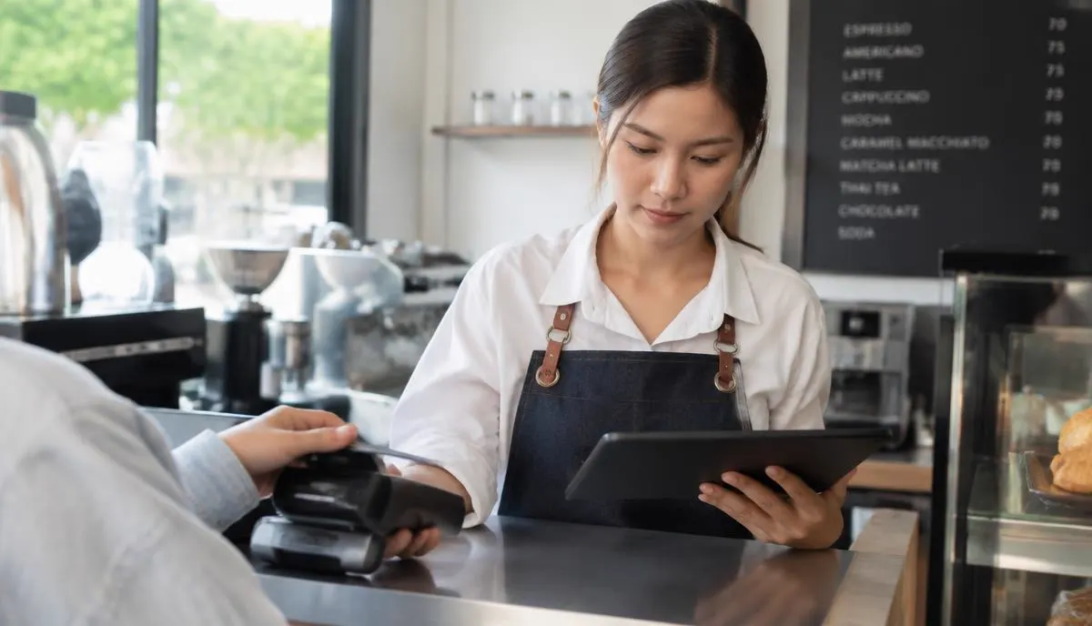 เจ้าของร้านรับชำระเงินด้วยบัตรผ่านเครื่องรับชำระและตรวจคำสั่งซื้อบนแท็บเล็ต